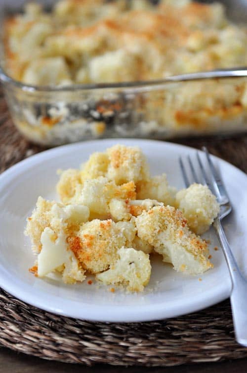 White plate of baked cauliflower with a fork next to it.