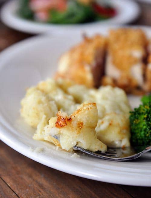 Creamy chantilly potatoes and a chicken breast on a white plate.