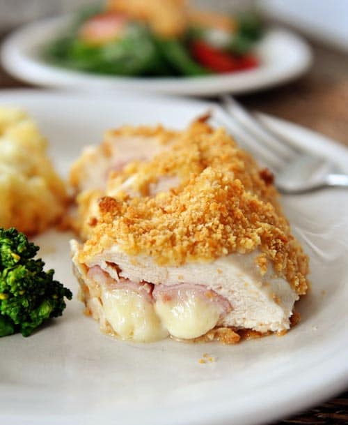 Chicken cordon bleu cut open on a white plate.