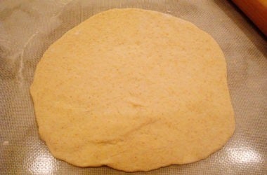 Bread dough rolled out in a circle.