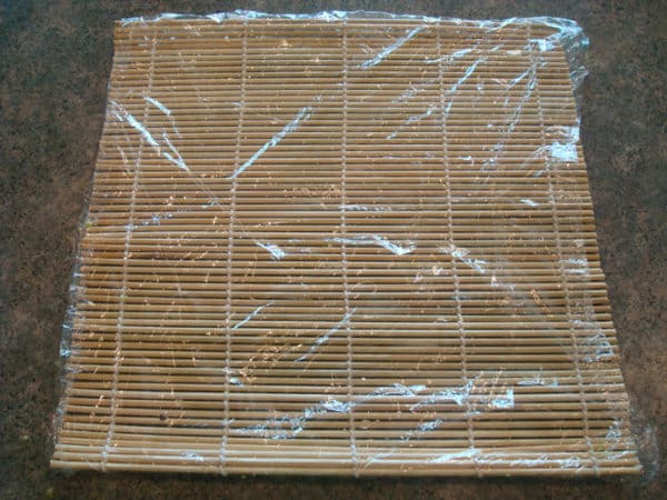 bamboo mat laid flat with plastic wrap on top