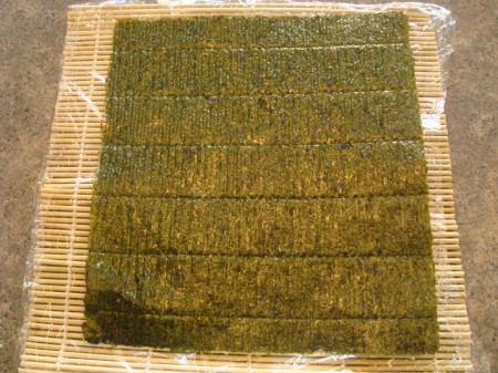 sheet of nori laid flat on a bamboo mat