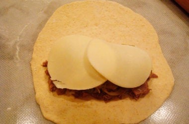 Unbaked bread dough with cheesesteak toppings inside.