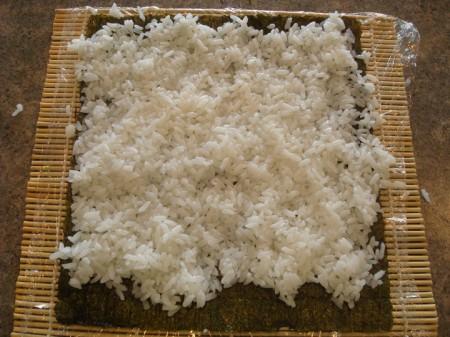 white rice spread on top of a sheet of nori