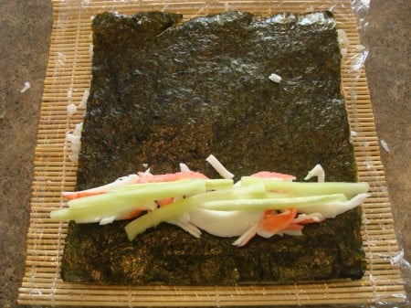 crab meat and cucumber sticks on a sheet of nori