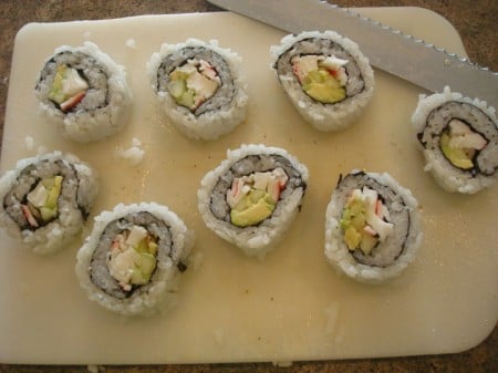 white cutting board with eight pieces of sushi roll