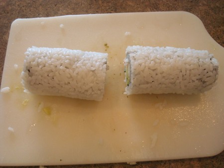 sushi roll on a white cutting board cut in half
