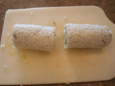 sushi roll on a white cutting board cut in half