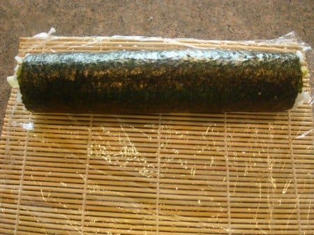 sheet of nori rolled up on a bamboo mat