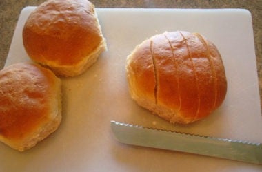 rolls on a white cutting board being cut into 1/2 inch strips