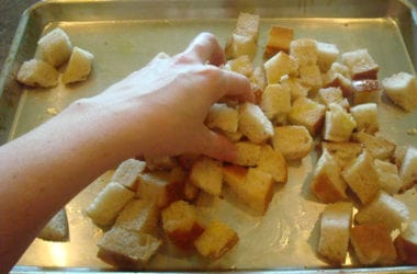 bread cubes drizzled with oil on a cookie sheet