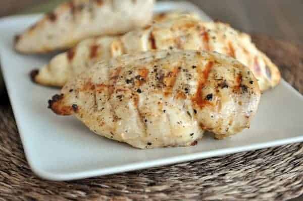 White plate with grilled chicken breasts.