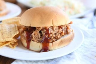 BBQ pork sandwich on bun on white plate