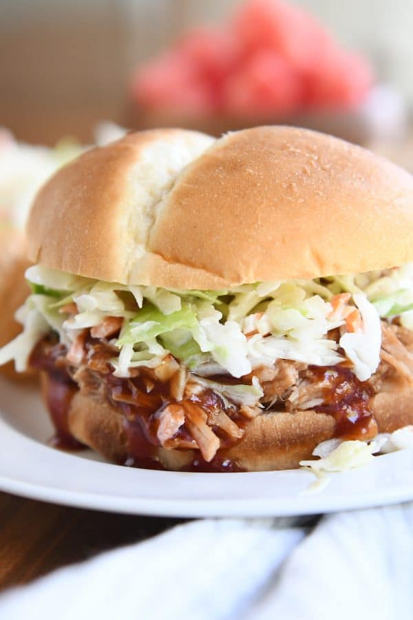 shredded BBQ pork sandwich with coleslaw on white plate