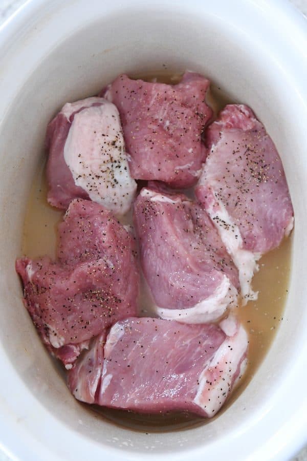 Uncooked pork roast in slow cooker.