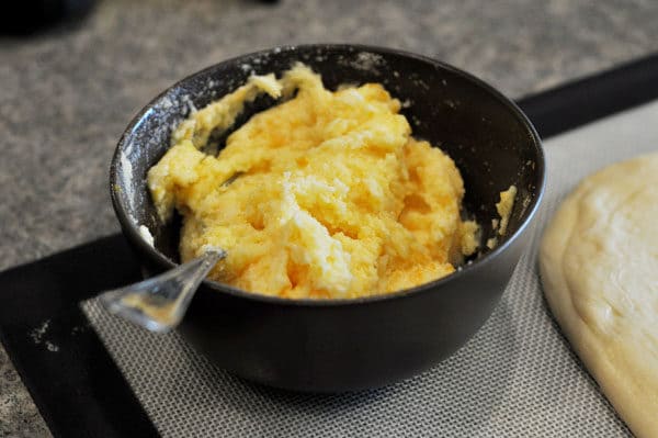 Orange zest and butter in a black bowl.