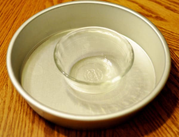 9-inch round cake pan with a small glass bowl sitting inside