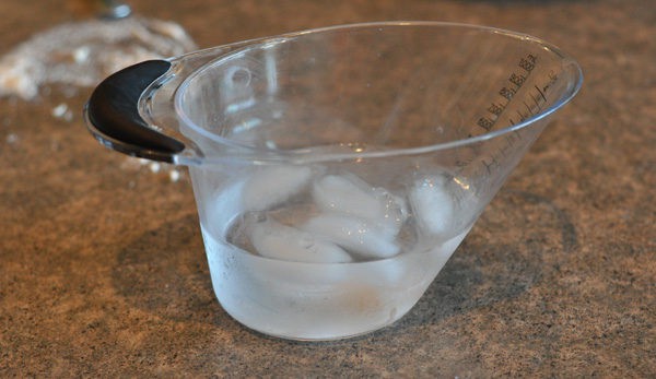clear measuring cup with ice water