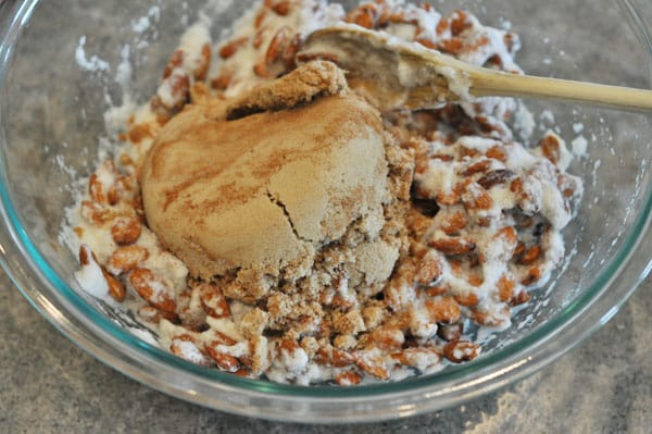 egg white coated almonds with brown sugar on top in a glass bowl