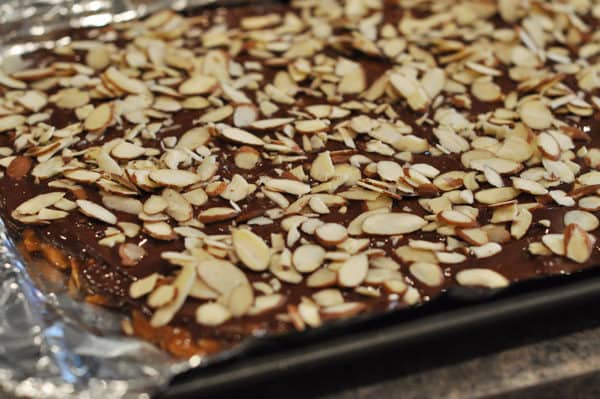 sliced almond covered almond roca on tinfoil lined cookie sheet