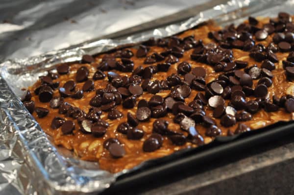 chocolate chip covered almond roca on a tinfoil lined cookie sheet