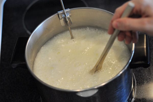 butter and sugar mixture being stirred in a pot with a wooden spoon