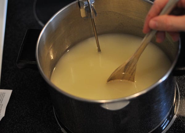 melted butter in a pot being stirred with a wooden spoon