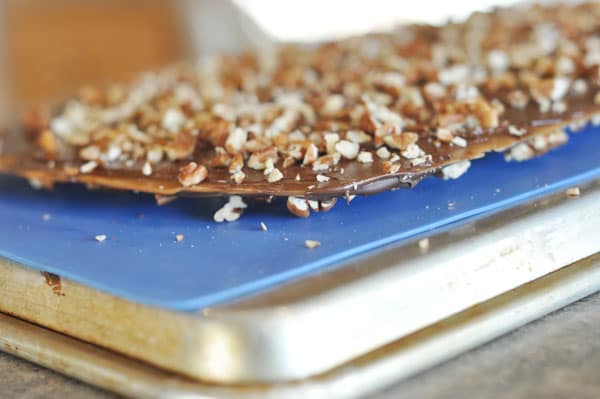 Toffee buttercrunch toffee on a blue liner on top of a cookie sheet.