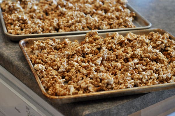 two cookie sheets full of toffee coated popcorn