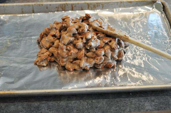 candy coated almonds piled on a tinfoil lined cookie sheet