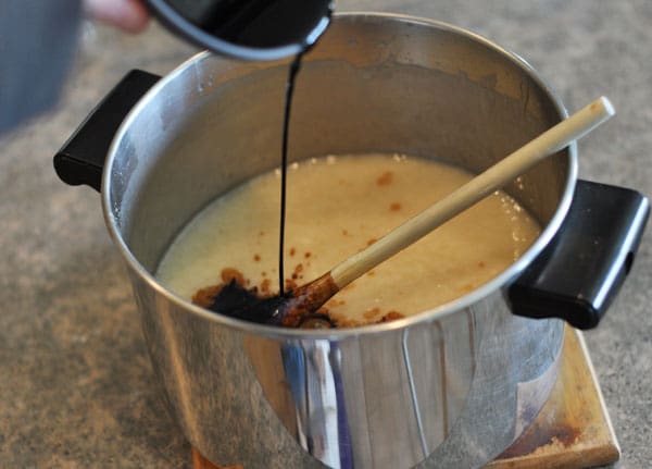 butter mixture in a pot with vanilla extract being poured in