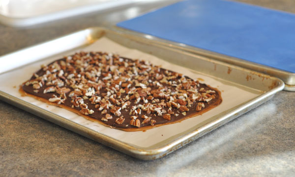 Pecan and toffee-topped buttercrunch on a cookie sheet.