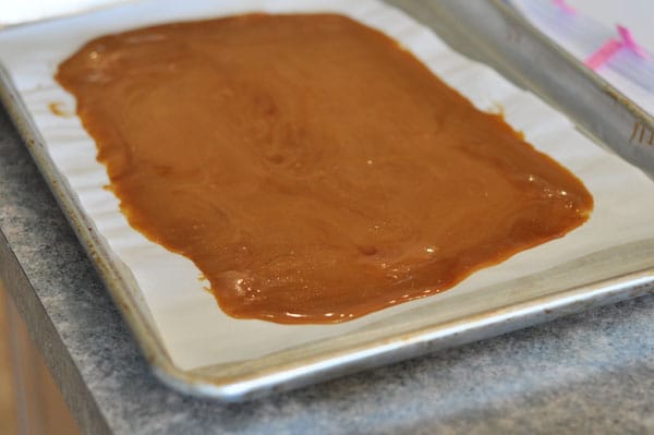 Toffee spread on a parchment paper on a cookie sheet.