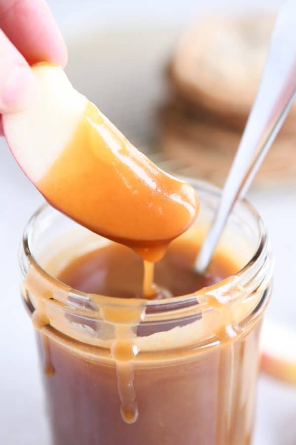 Dipping apple slice in homemade caramel sauce.