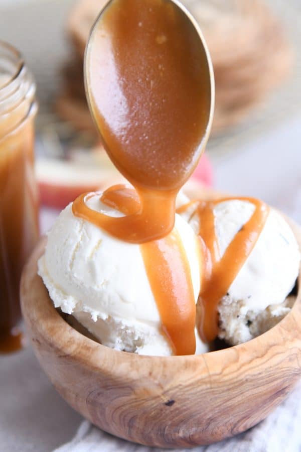 Drizzling homemade caramel sauce on ice cream.