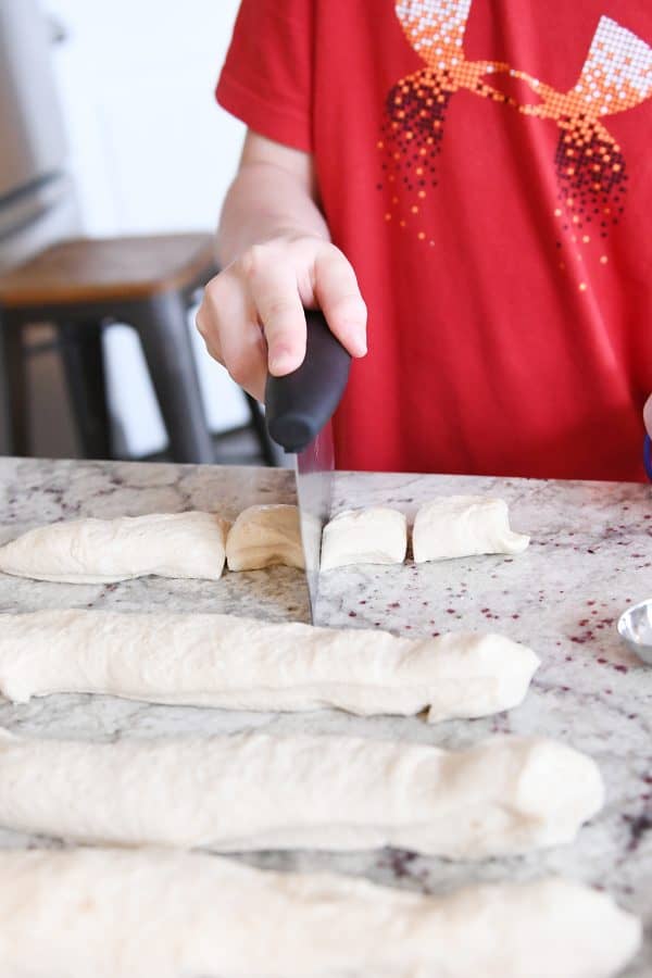 Cutting pretzel bite dough into pieces.