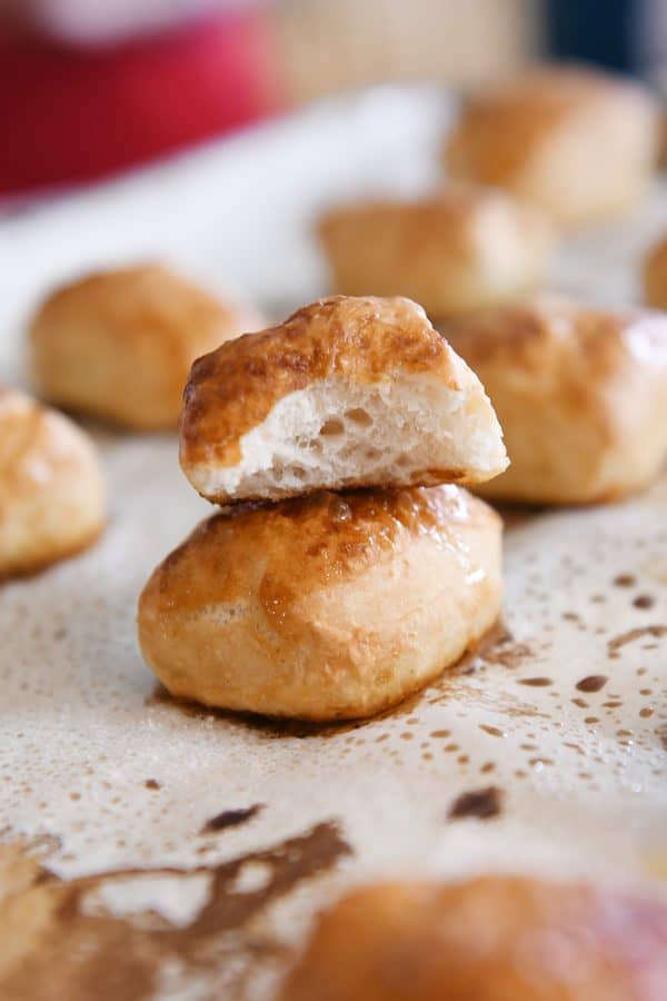 soft pretzel bite in half on top of another pretzel bite on sheet pan