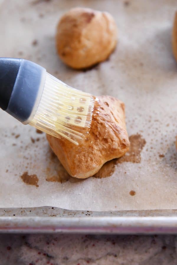 Brushing baked pretzel bites with butter.