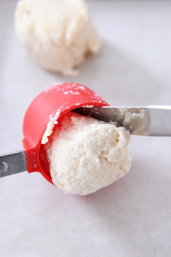 Scooping dough out of measuring cup for buttermilk drop biscuits