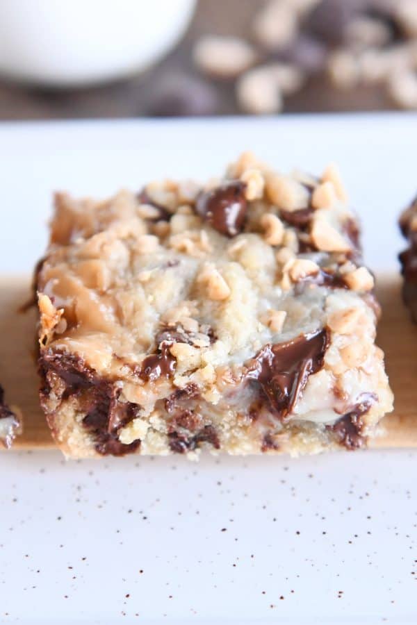 One chocolate chip toffee bar cut into square shape on wood stick.