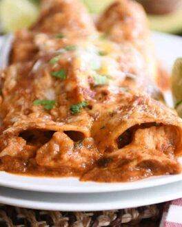 Two of the best red sauce chicken enchiladas on white plate.