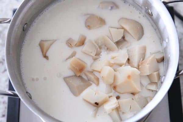 Adding baked potatoes to soup.