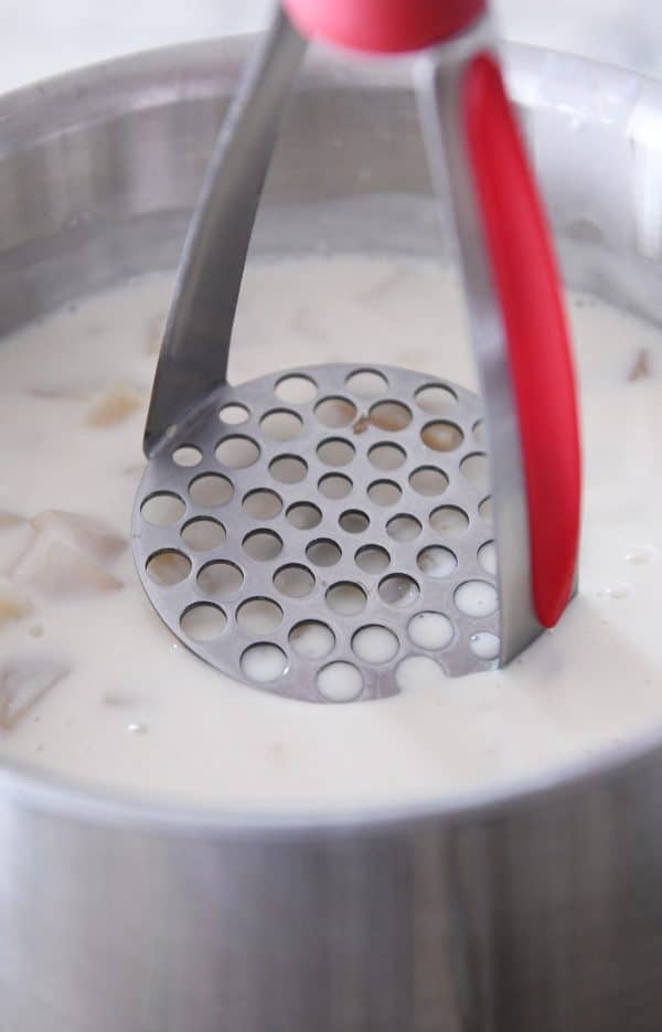 Mashing potatoes in loaded baked potato soup.