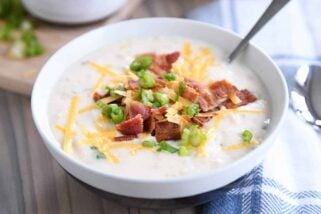 spoon in white bowl with easy loaded baked potato soup