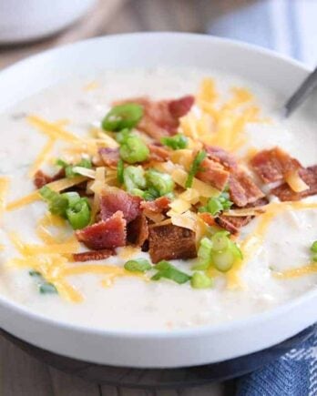 spoon in white bowl with easy loaded baked potato soup