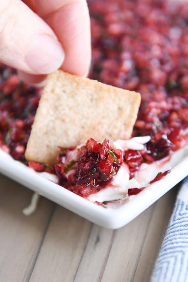 Dipping wheat thin cracker into cranberry-jalapeno cream cheese dip.