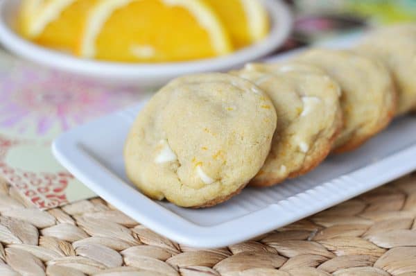 White platter with white chocolate chip creamsicle cookies lined up on it.