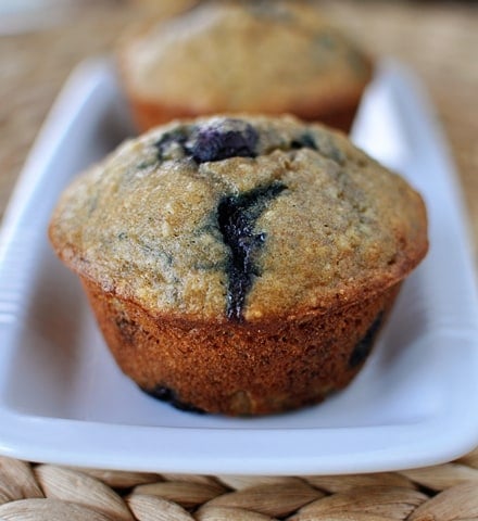 Banana blueberry muffins lined up on a rectangular white platter.