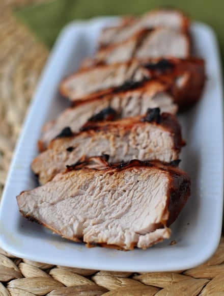 Top view of sliced grilled tenderloin on a white platter.