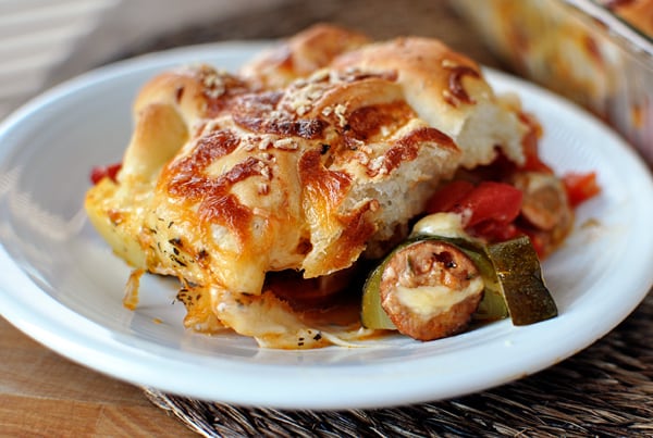 A big serving of cheesy breadstick pizza casserole on a white plate.